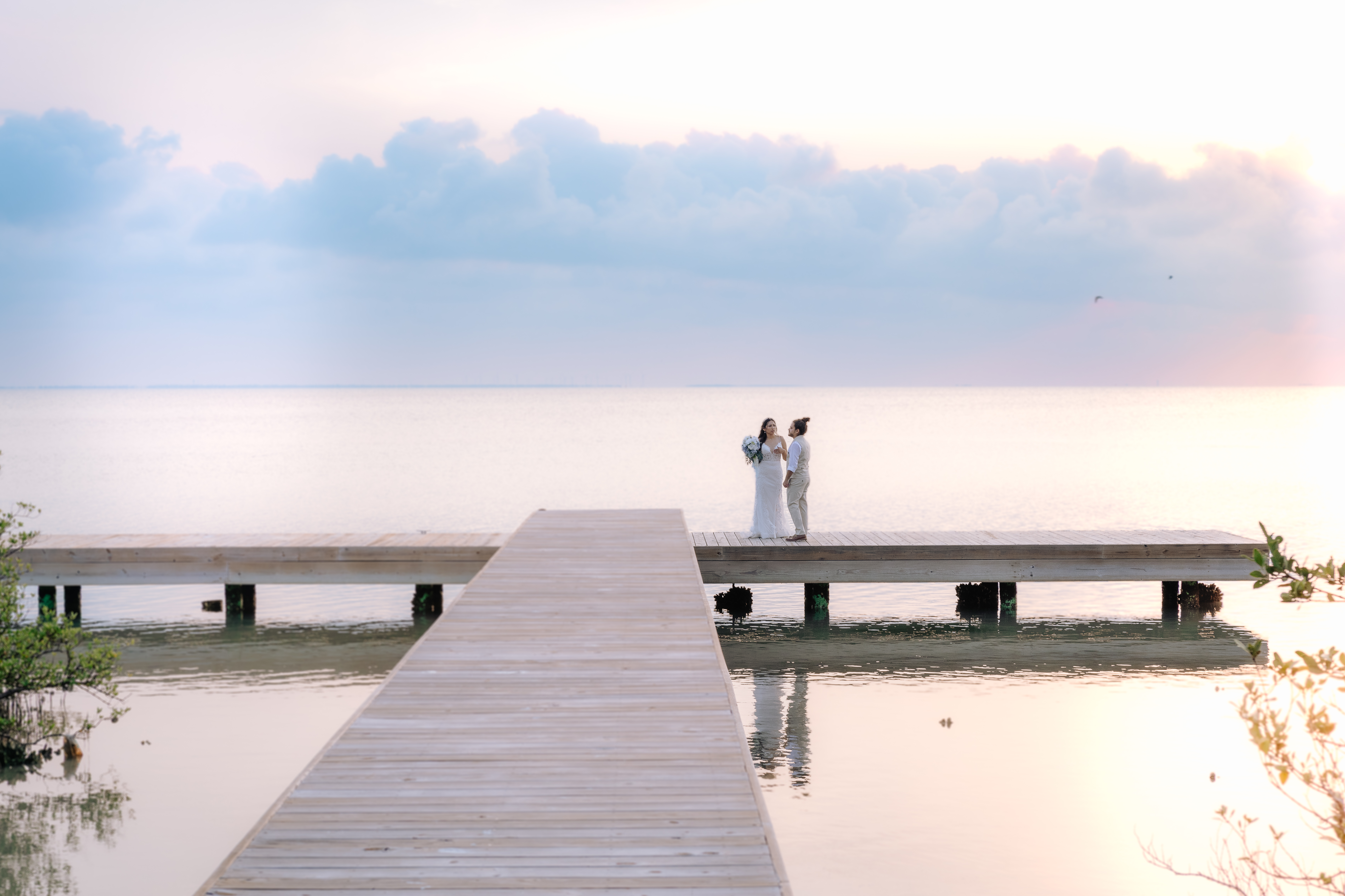 Bride and groom on a dock at sunset over calm water in the Texas Hill Country — Weddings by Wendi