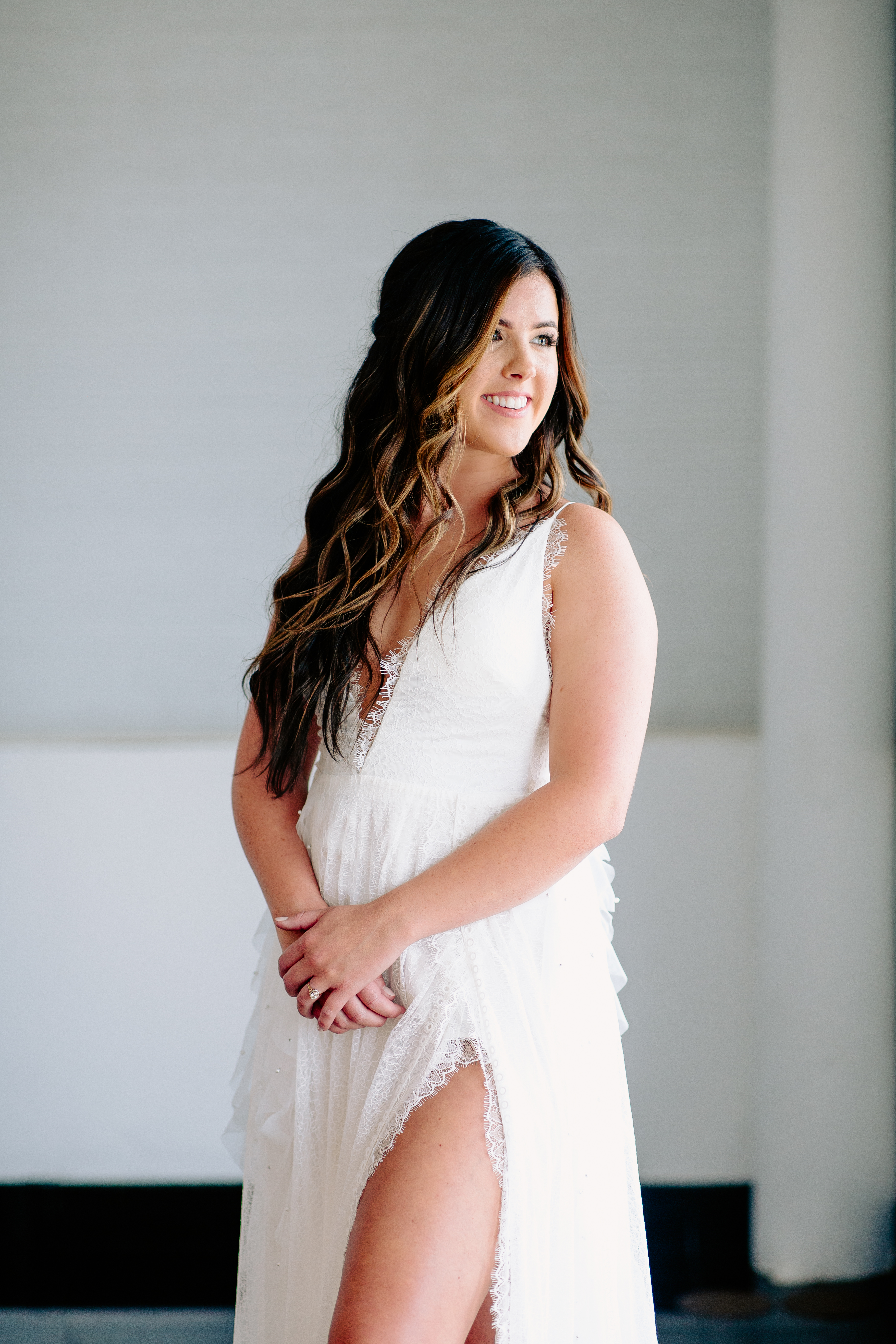 Bride smiling in a lace v-neck wedding gown, hair in soft waves, photographed by Weddings by Wendi