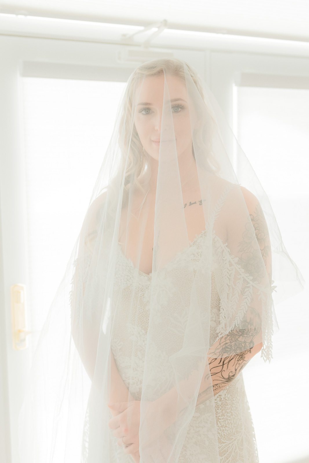 Bride in elegant lace gown under cathedral veil, soft window light, Hill Country wedding portrait by Weddings by Wendi