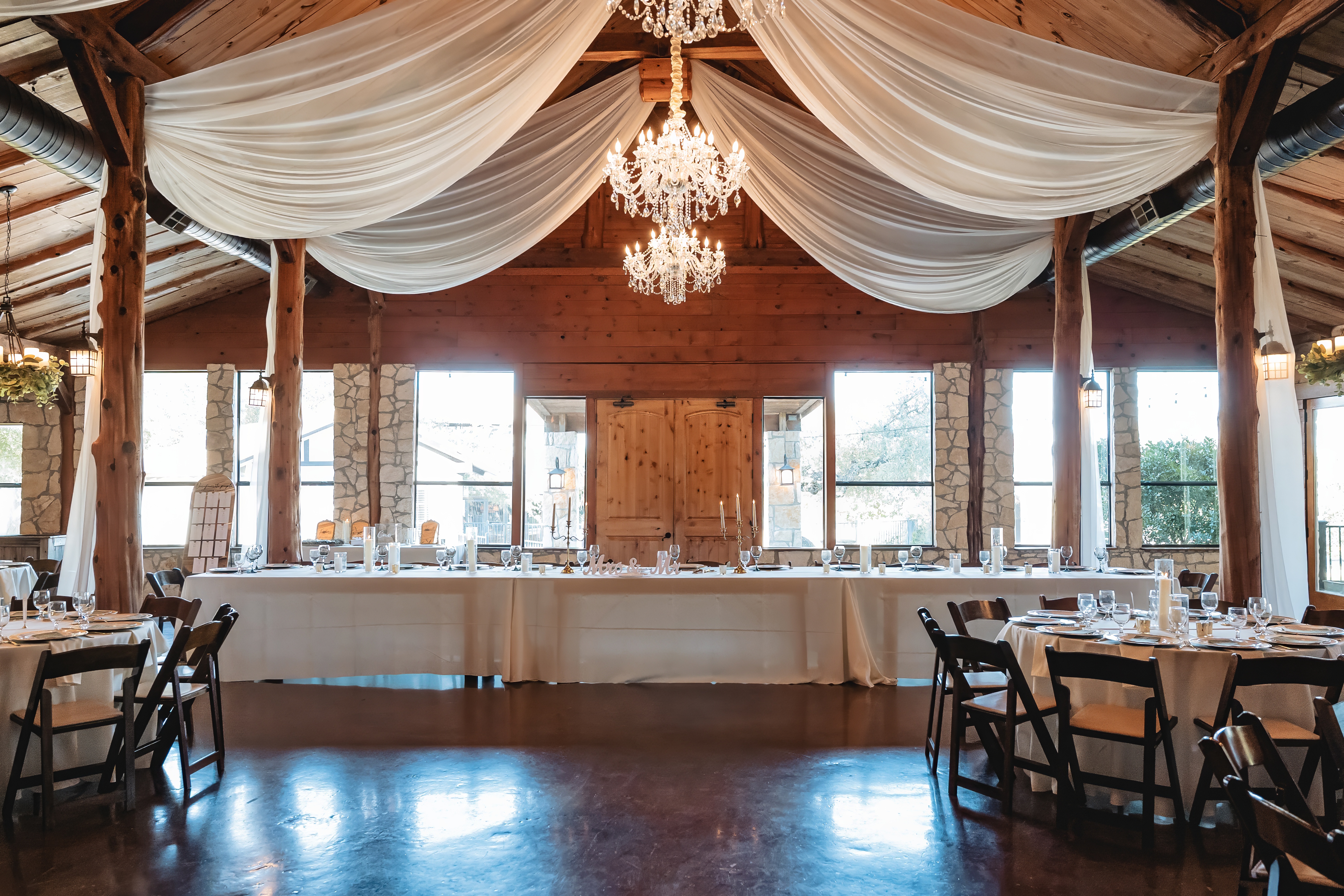 Reception hall with crystal chandelier and draped ceiling — Memory Lane Ranch all-inclusive wedding venue Dripping Springs Texas