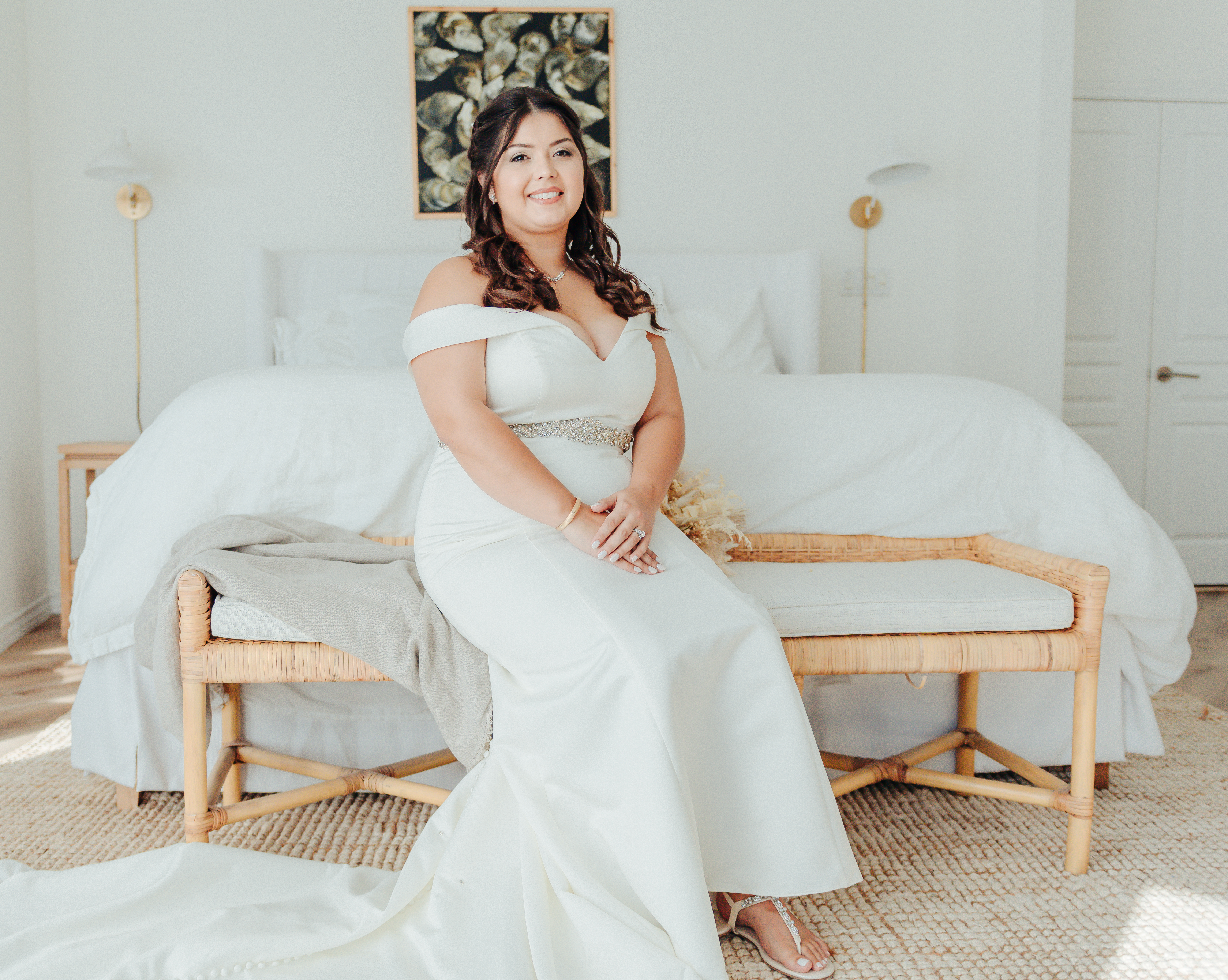 Bride sitting in elegant white gown on wooden bench, bridal portrait by Weddings by Wendi