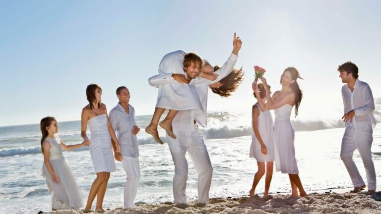 a group of people standing on top of a sandy beach