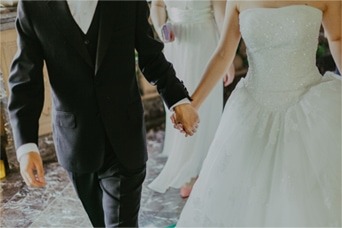 a bride and groom holding hands in front of other people