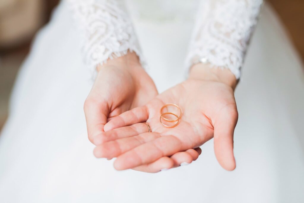 a woman holding two wedding rings in her hands