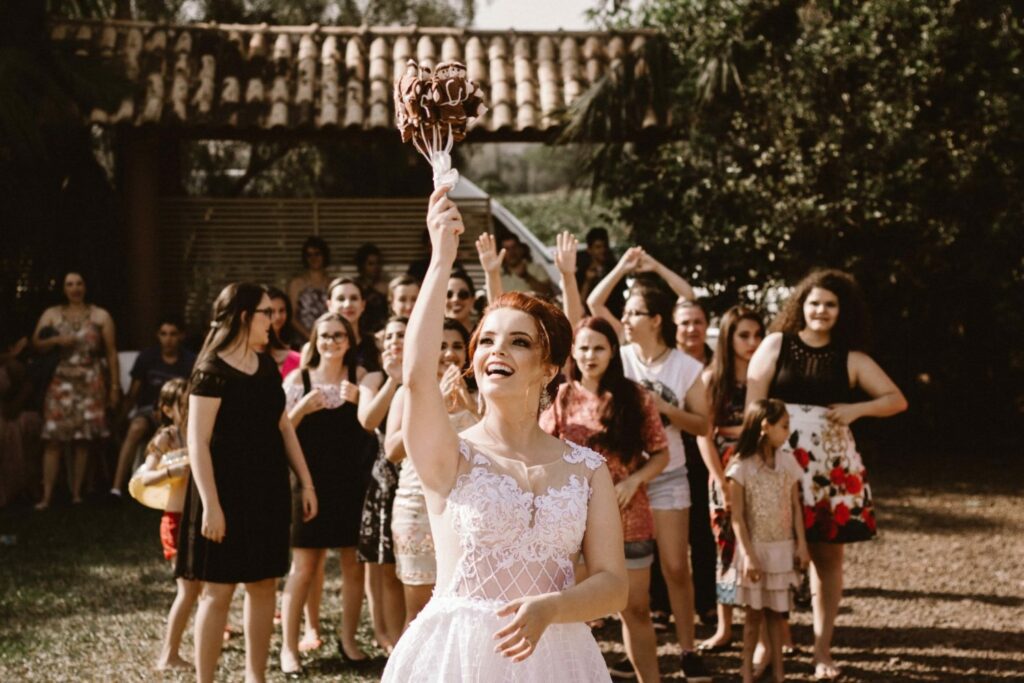 a woman in a wedding dress holding up a bouquet backyard wedding