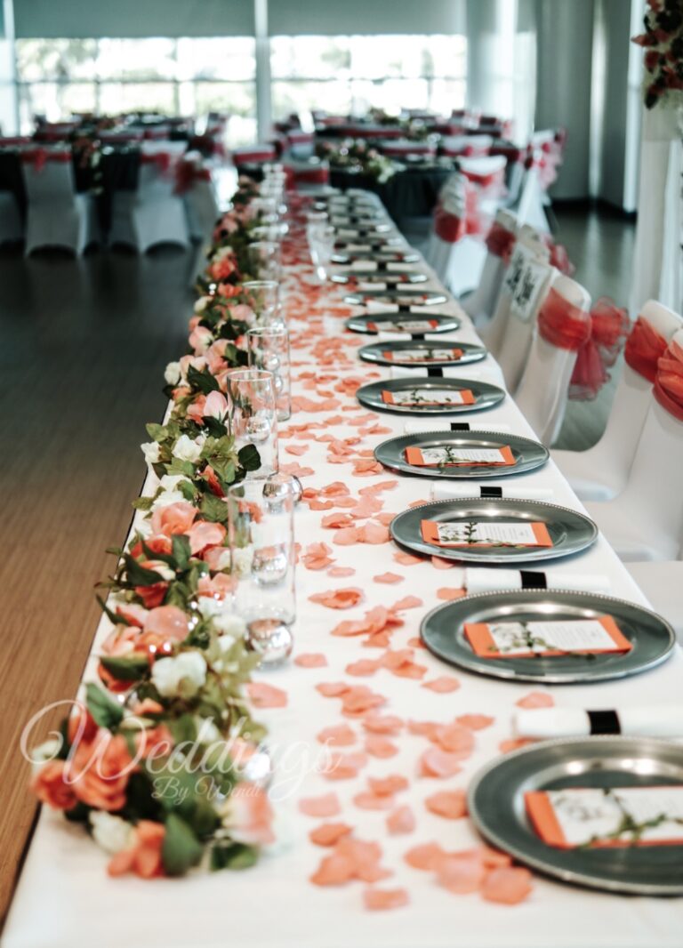 a long table with plates and flowers on it