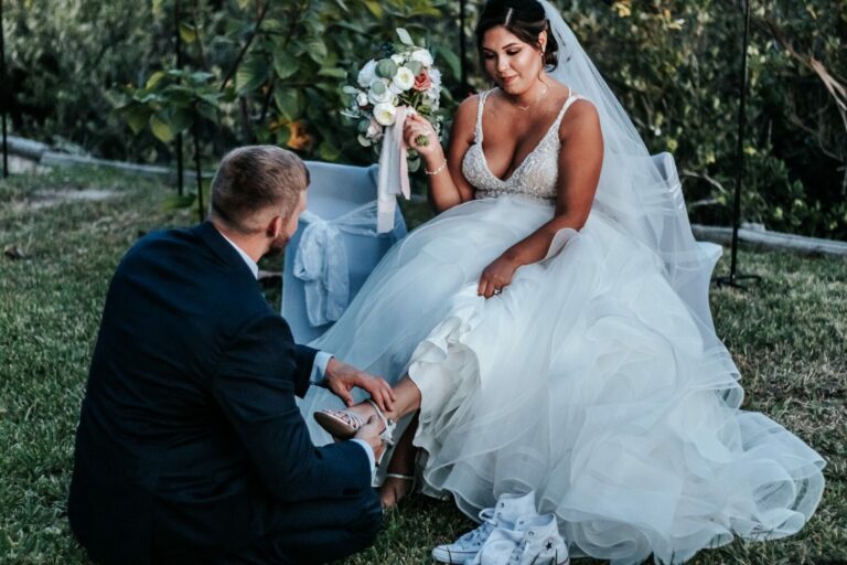 a man kneeling down next to a woman in a wedding dress