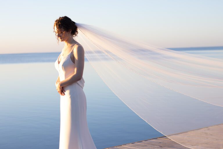 a woman in a wedding dress standing on a dock