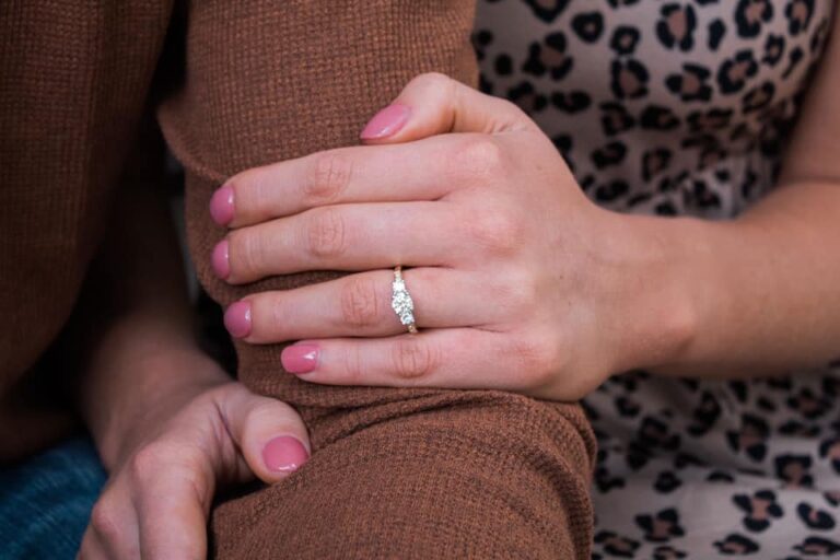 a woman's hands holding onto her engagement ring