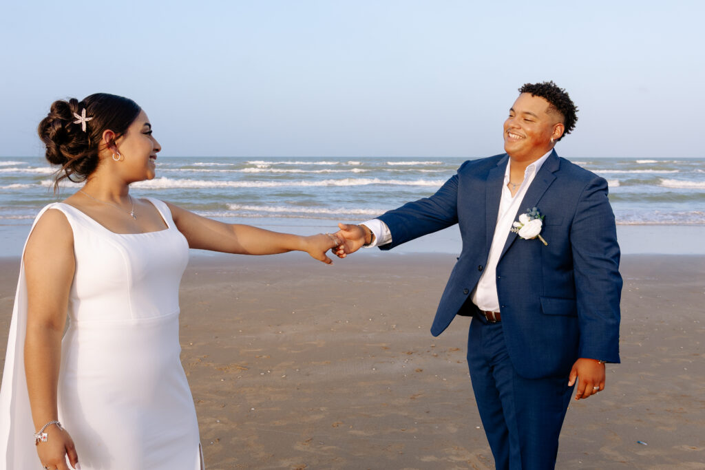 a man and woman holding hands on a beach
