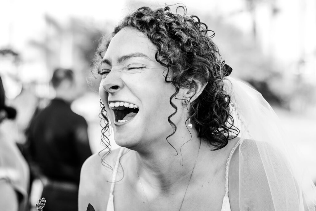 a woman laughing with her eyes closed