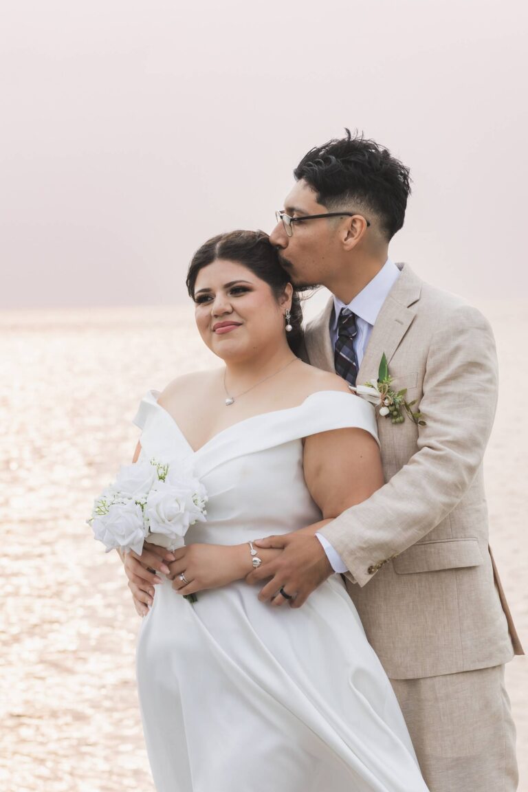 a man kissing a woman in a wedding dress