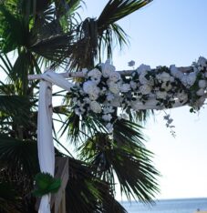 a white wedding arch with flowers on it