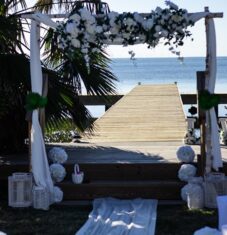 a wooden dock with flowers and greenery on it