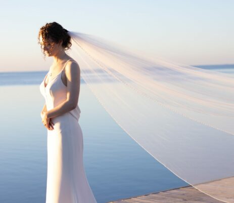 a woman in a wedding dress standing on a dock