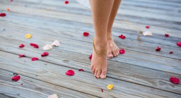 a woman standing on a wooden floor with rose petals