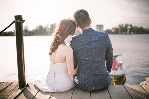 a man and woman are sitting on a dock