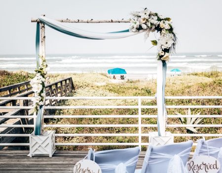 a wedding set up on the beach with blue and white decor