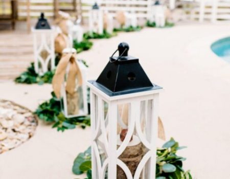 a couple of white lanterns sitting next to a pool