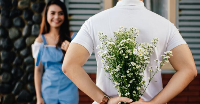 Man Holding Baby's-breath Flower in Front of Woman Standing Near Marble Wall