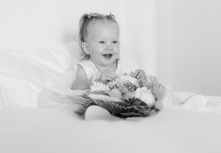 Full Wedding Planning - - Weddings By Wendi a little girl sitting on a bed holding a bouquet of flowers
