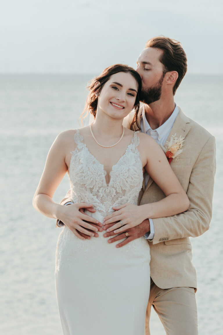 a man kissing a woman in a wedding dress