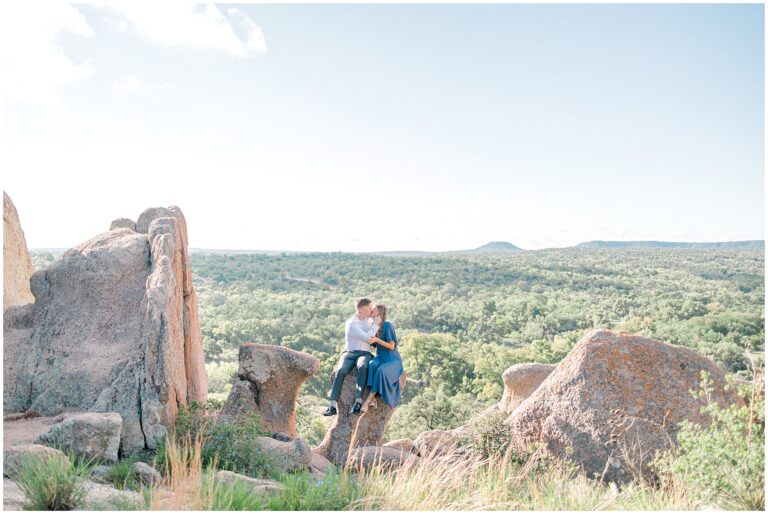 a man and woman sitting on a rock